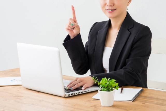 PCを使用する人物と植物